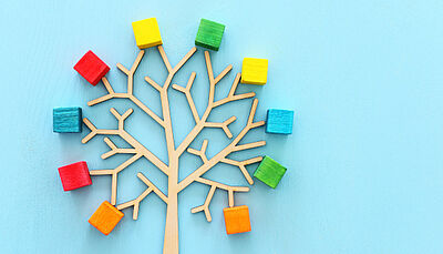 Business image of wooden tree with colorful cubes over blue table, human resources and management concept