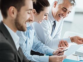 Une équipe de professionnels discute dans la bonne humeur des objectifs à atteindre. Les promesses de Dauphine Executive Education, formation continue de l'Université Paris Dauphine-PSL.
